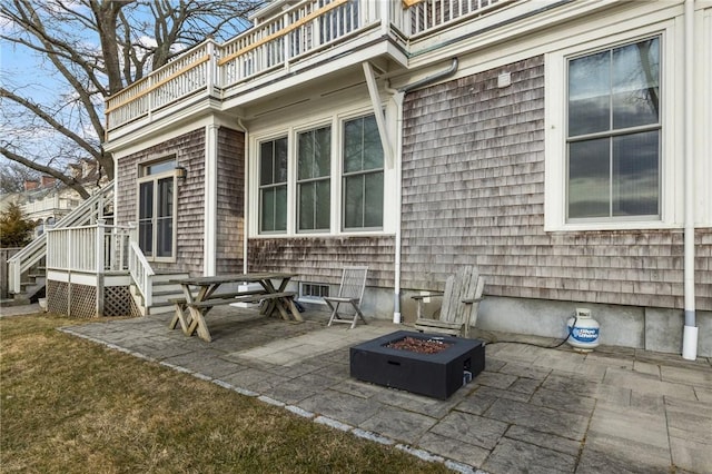 view of patio / terrace featuring an outdoor fire pit and a balcony