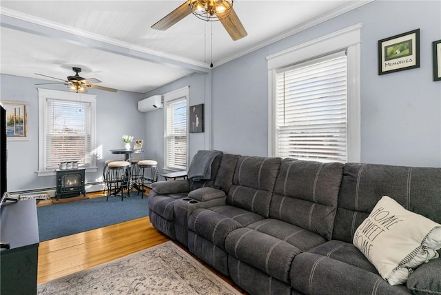 living area featuring a wall unit AC, a wood stove, wood finished floors, and ceiling fan