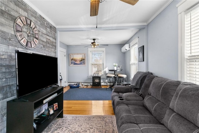 living area with wood finished floors, an AC wall unit, ornamental molding, and a ceiling fan