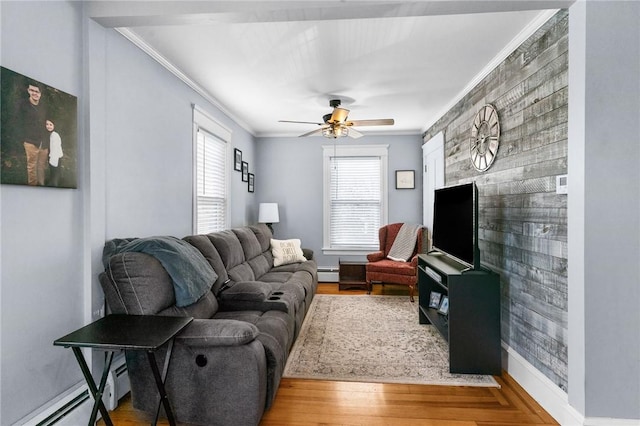 living room with crown molding, wood finished floors, an accent wall, and a baseboard radiator