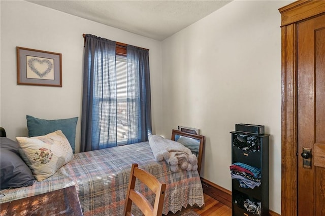 bedroom with baseboards and wood finished floors