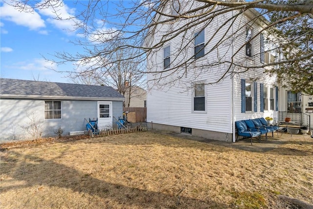 rear view of property featuring a yard and a shingled roof