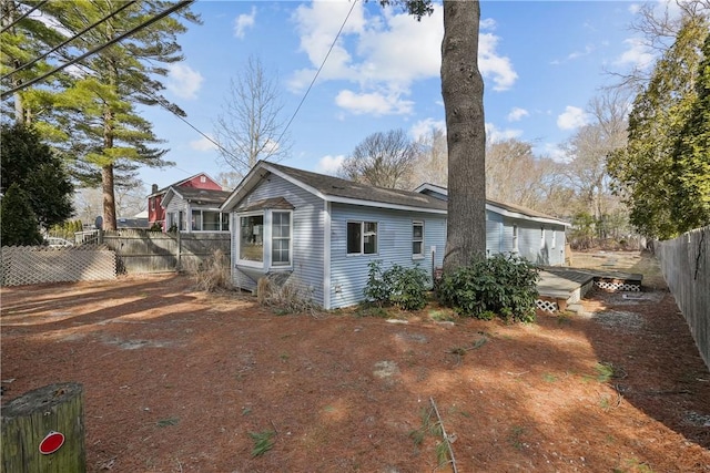 rear view of property with a wooden deck and fence