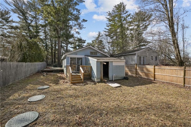 rear view of property featuring an outbuilding and a fenced backyard