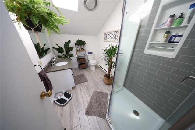 bathroom with toilet, vanity, a shower stall, lofted ceiling, and wood tiled floor