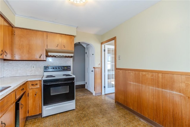 kitchen featuring arched walkways, range with electric cooktop, light countertops, under cabinet range hood, and wainscoting