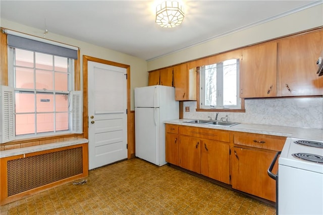 kitchen featuring a sink, white appliances, radiator, light countertops, and decorative backsplash