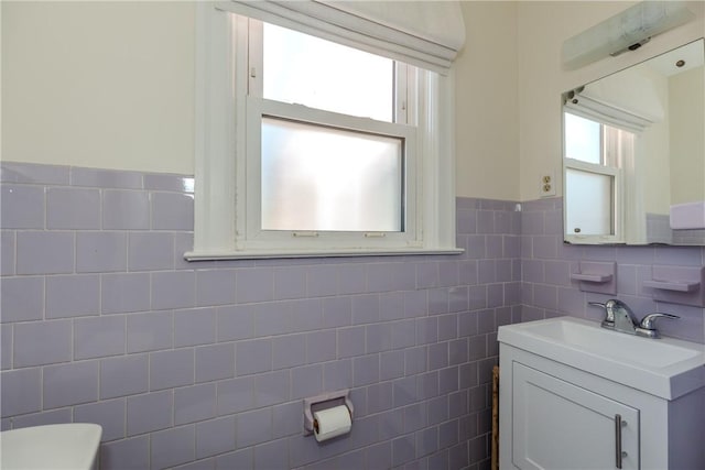 bathroom featuring vanity, tile walls, and wainscoting