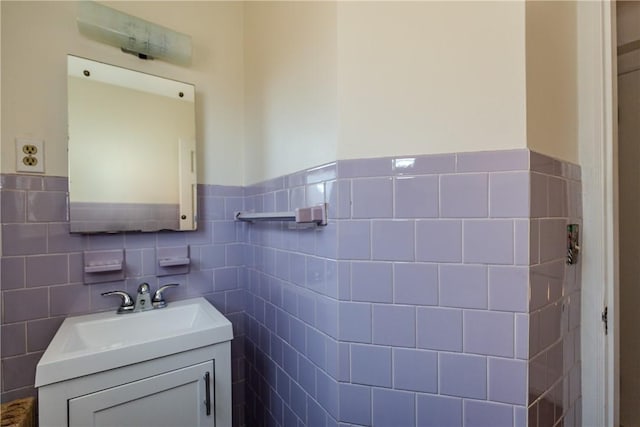 bathroom with wainscoting, vanity, and tile walls