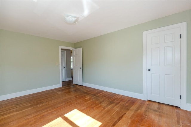 spare room featuring baseboards and light wood-style floors