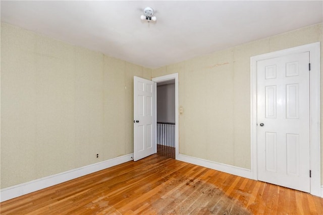 spare room with hardwood / wood-style floors and baseboards