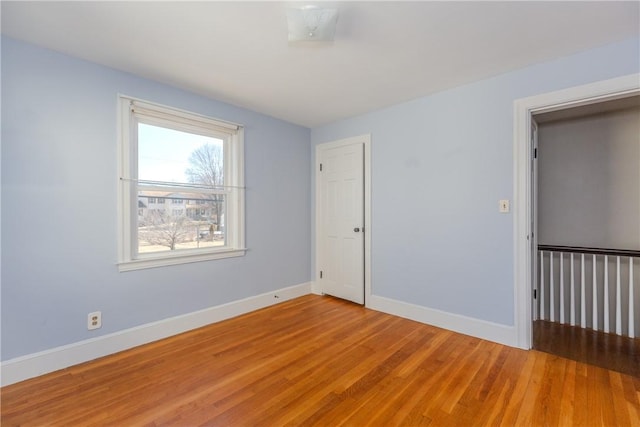 spare room featuring baseboards and light wood-style floors