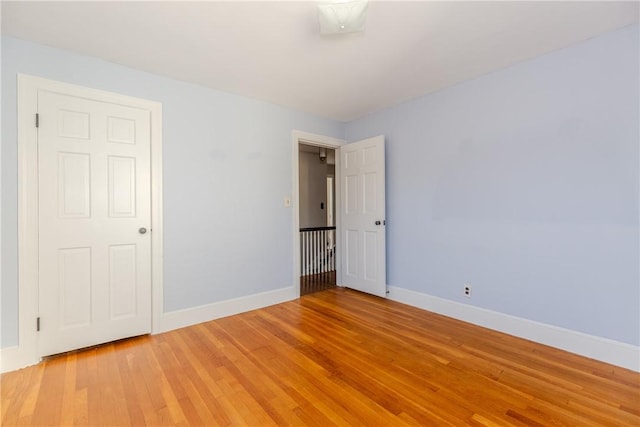 spare room with baseboards and light wood-style flooring