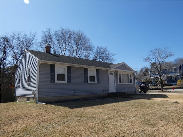 view of front of home with roof with shingles, a chimney, and a front yard