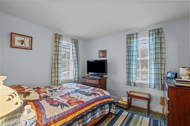 bedroom featuring multiple windows, baseboards, and carpet floors