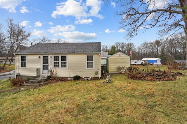 back of property with a lawn and a shingled roof