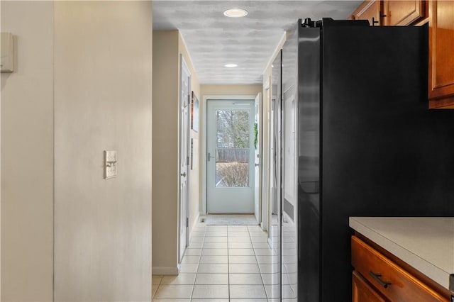 hall with baseboards and light tile patterned floors