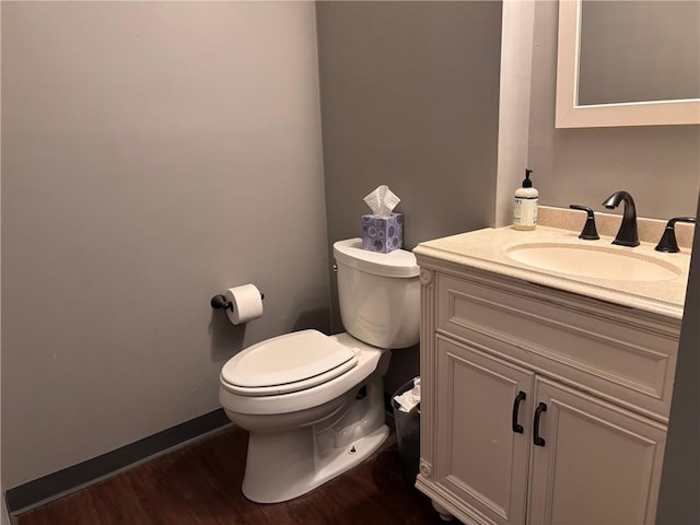 bathroom featuring toilet, vanity, and wood finished floors