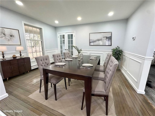 dining area with recessed lighting, french doors, a decorative wall, and light wood finished floors