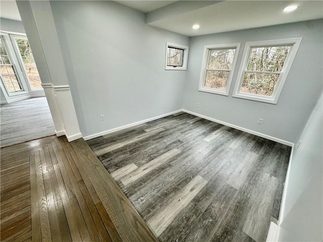 spare room featuring recessed lighting, baseboards, and dark wood-style flooring