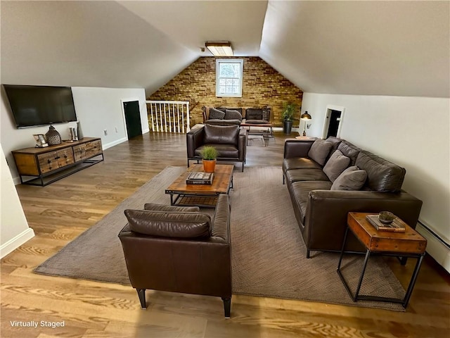 living room with wood finished floors, baseboards, brick wall, lofted ceiling, and baseboard heating