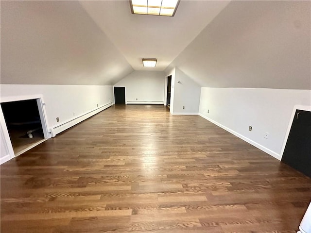 additional living space with baseboard heating, lofted ceiling, and wood finished floors