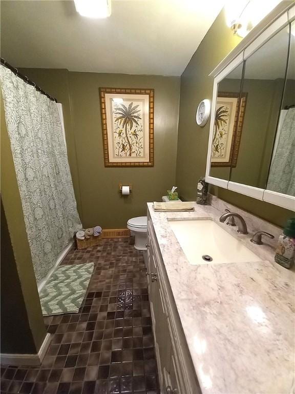 bathroom featuring vanity, a shower with shower curtain, toilet, and baseboards