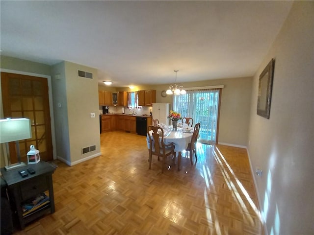 dining area featuring a notable chandelier, visible vents, and baseboards