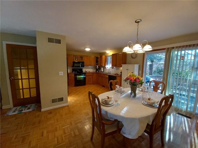 dining room with visible vents, baseboards, and an inviting chandelier