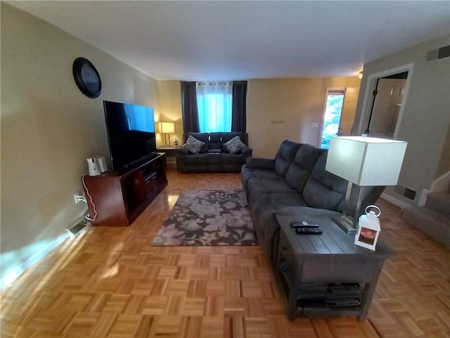 living room featuring baseboards and visible vents