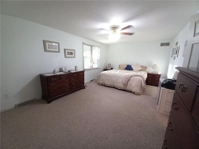 bedroom featuring light colored carpet, visible vents, and ceiling fan