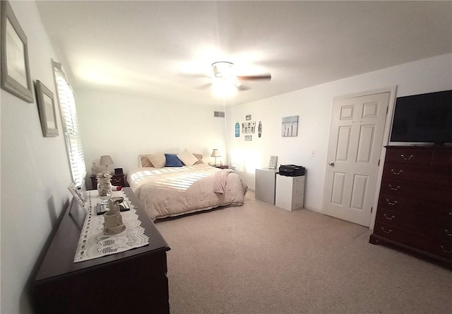 carpeted bedroom with a ceiling fan and visible vents