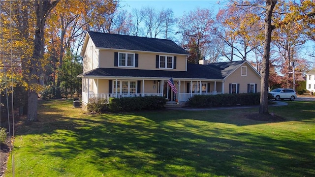 view of front of house featuring a porch, a chimney, and a front lawn