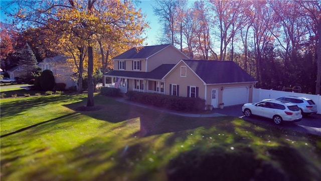 view of front of house with aphalt driveway, a porch, an attached garage, and a front yard