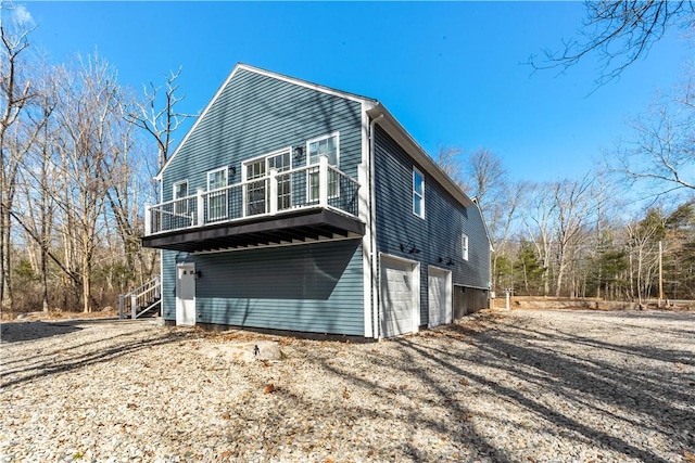 view of home's exterior with a garage, a deck, and driveway