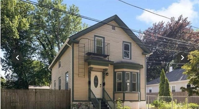 view of front of property featuring entry steps and fence