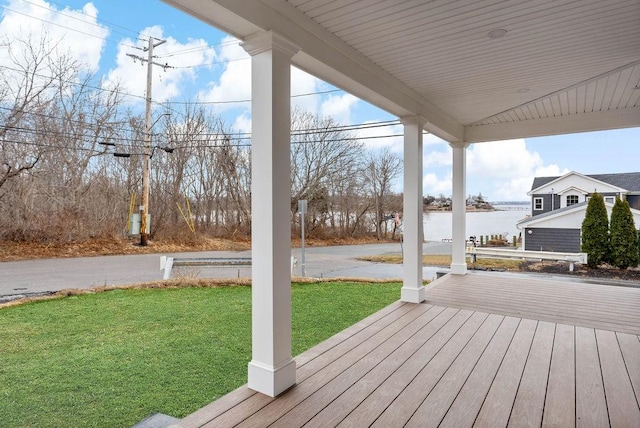 deck with a yard and a water view