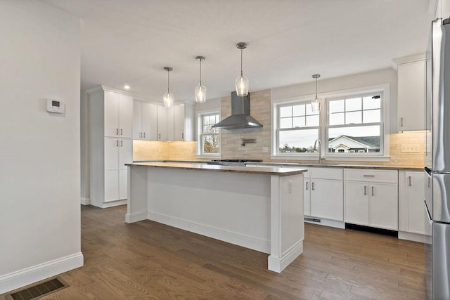 kitchen featuring visible vents, dark wood-type flooring, wall chimney exhaust hood, and white cabinets