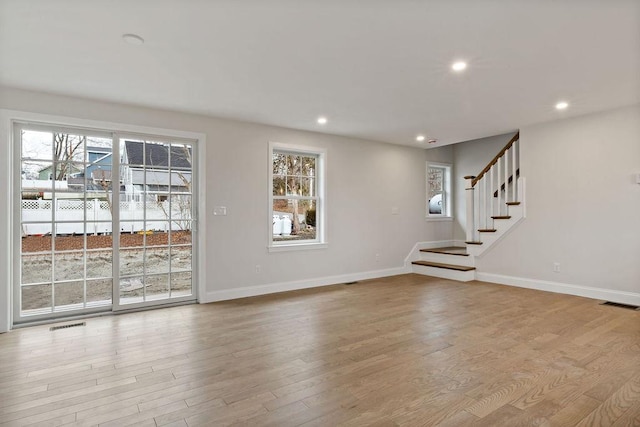 spare room with recessed lighting, stairs, baseboards, and wood finished floors