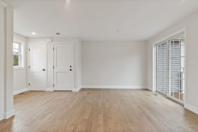 spare room with light wood finished floors and baseboards