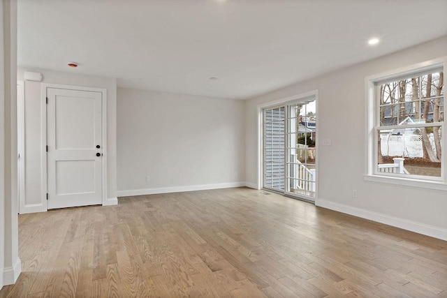 empty room featuring recessed lighting, baseboards, and light wood finished floors