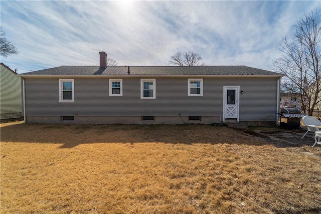 back of property with a lawn and a chimney