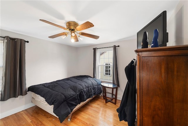 bedroom with baseboards, ceiling fan, and light wood finished floors