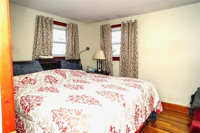 bedroom with baseboards and wood finished floors