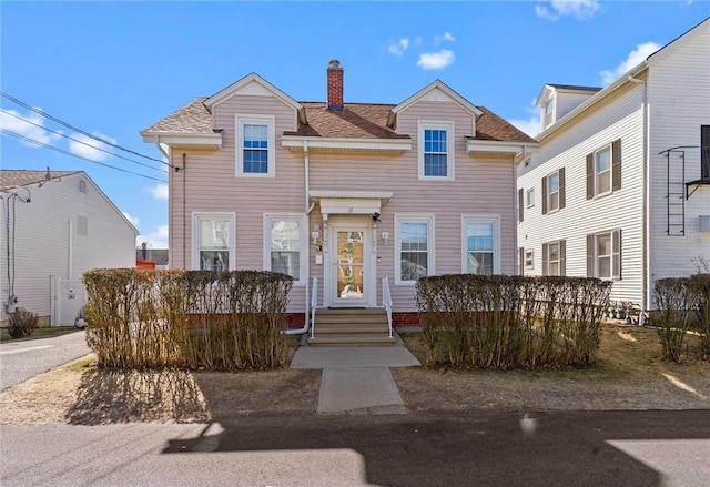 view of front of home featuring a chimney and a shingled roof