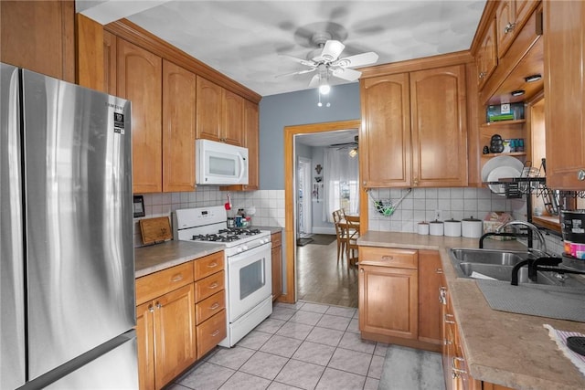 kitchen with backsplash, ceiling fan, light tile patterned flooring, white appliances, and a sink