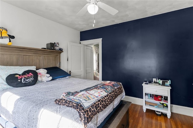 bedroom with a ceiling fan, baseboards, and wood finished floors