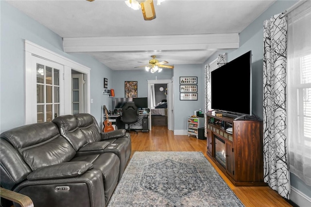 living room with french doors, baseboards, light wood-style floors, and ceiling fan