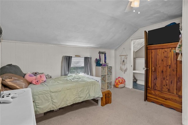 carpeted bedroom featuring lofted ceiling, ensuite bath, and ceiling fan