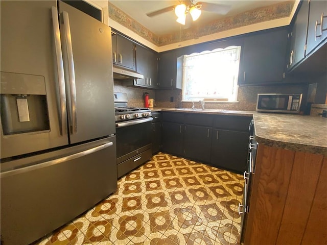 kitchen featuring light floors, a sink, stainless steel appliances, under cabinet range hood, and tasteful backsplash